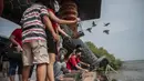 Orang-orang melepaskan burung saat merayakan awal Tahun Baru Imlek yang menyambut Tahun Macan di Surabaya pada 1 Februari 2022. (Juni Kriswanto / AFP)