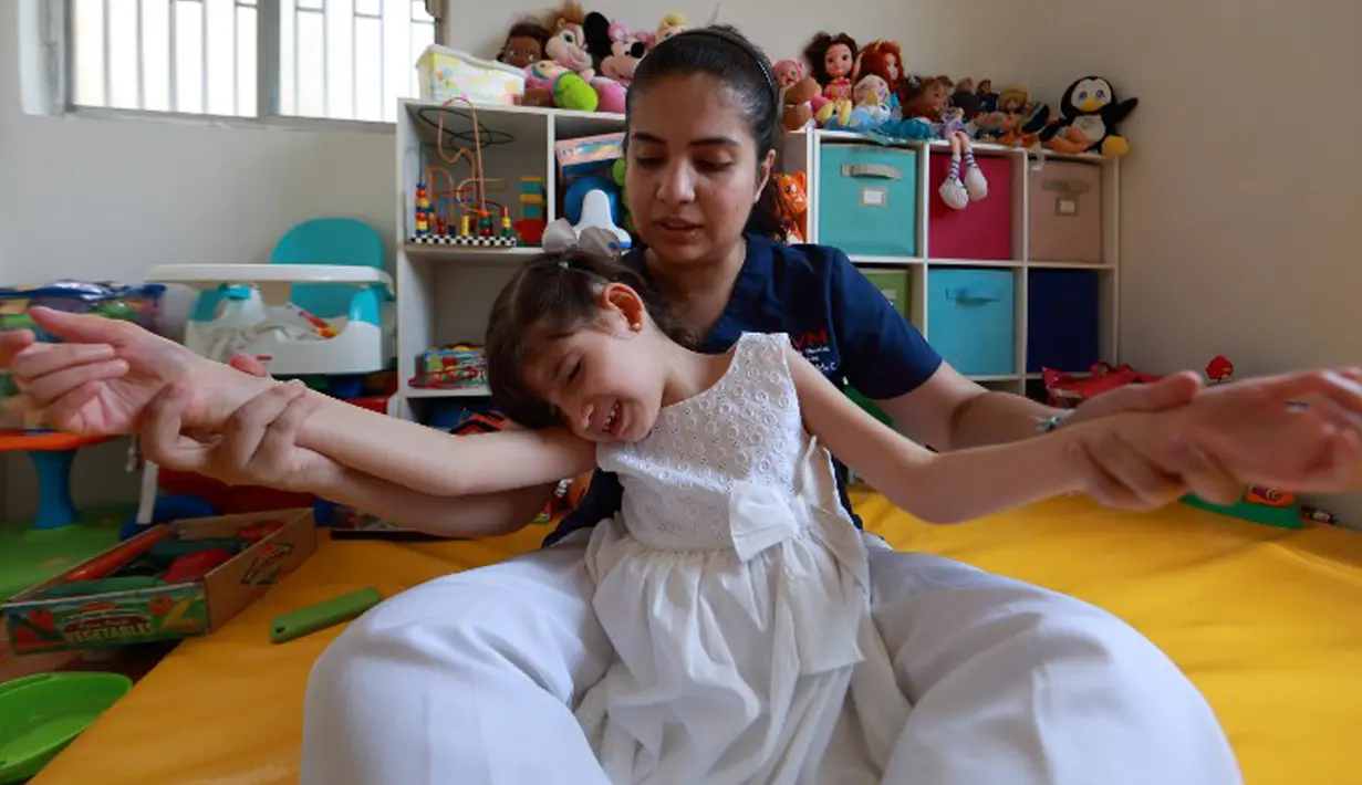 Graciela Elizalde (8), pengidap epilepsi langka dan cukup berat, saat terapi di rumahnya di Monterrey, Meksiko, 2 September 2015. Hakim federal setempat memberikan izin kepada Graciela menggunakan ganja untuk keperluan medis. (AFP PHOTO/CARLOS RAMIREZ)