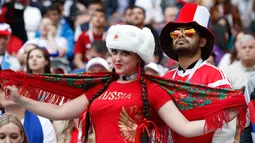 Suporter wanita tersenyum saat bersiap mendukung negaranya pada pertandingan grup A Piala Dunia 2018 antara Rusia dan Arab Saudi di stadion Luzhniki di Moskow, (14/6). Dalam pertandingan ini, Rusia menang 5-0 atas Arab Saudi. (AP Photo/Antonio Calanni)