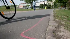 Gambar pada 8 Mei 2019 menunjukkan garis berwarna pink yang diperuntukkan bagi bandar narkotika di aspal Taman Goerlitzer, Berlin. Nantinya, para bandar hanya boleh bertransaksi di dalam zona berupa coretan kotak dengan cat semprot berwarna pink itu saja. (Paul Zinken / dpa / AFP)