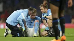 Gelandang Manchester City, Kevin De Bruyne mendapatkan perawatan tim medis setelah mengalami cedera saat menghadapi Inter Milan pada laga final Liga Champions 2022/2023 di Ataturk Olympic Stadium, Istanbul (10/6/2023). (AP Photo/Francisco Seco)