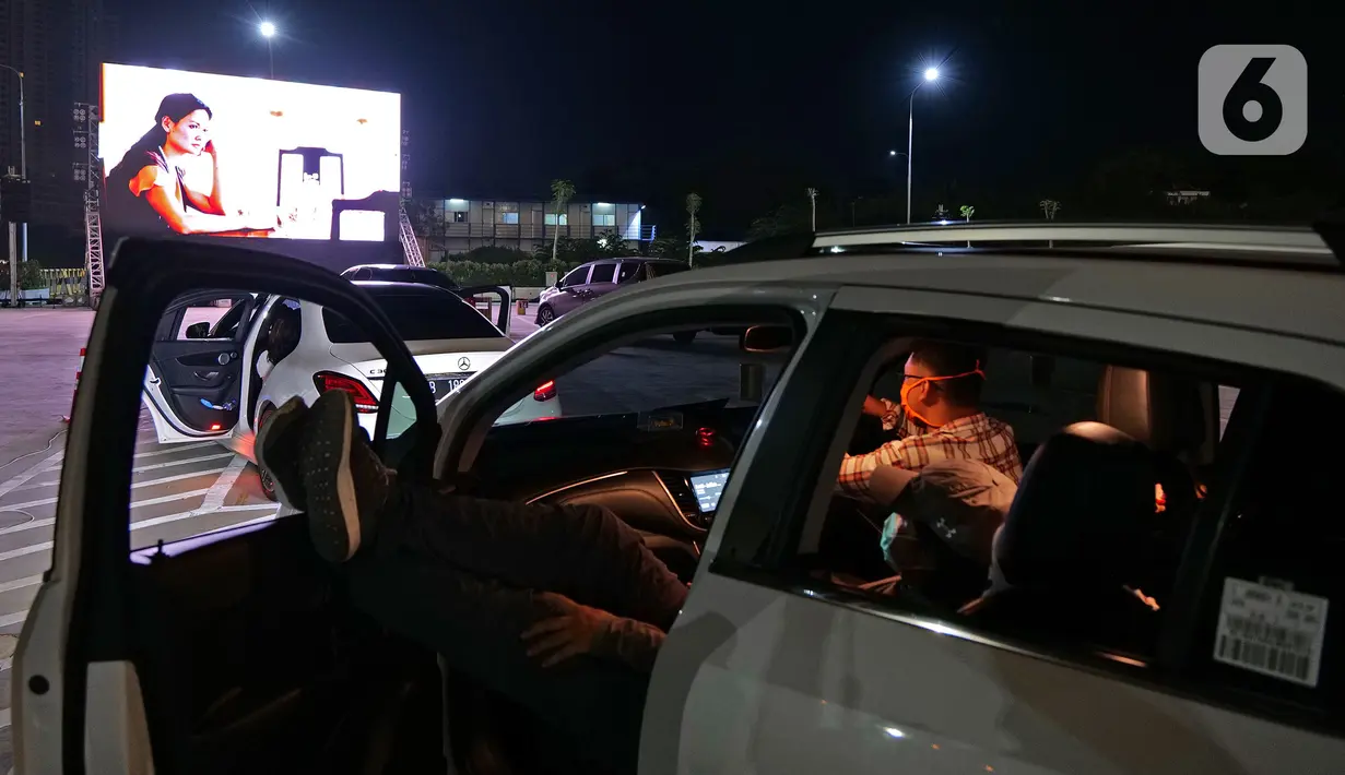Penonton menyaksikan pemutaran film secara drive-in di Cikarang, Bekasi, Jawa Barat, Rabu (3/6/2020). Jelang new normal, pengelola pusat hiburan menghadirkan konsep gaya hidup dengan standar protokol kesehatan. (Liputan6.com/Herman Zakharia)