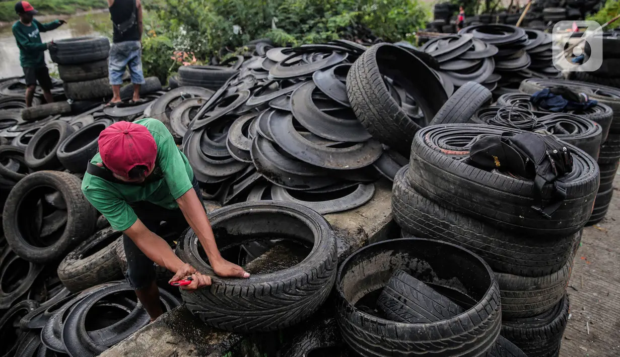 Pekerja memotong ban mobil bekas di kawasan Petamburan, Jakarta, Minggu (12/12/2021). Agoes (45) memotong ban hanya mendapat Rp 250 rupiah untuk satu ban yang berhasil dipotong. (Liputan6.com/Faizal Fanani)