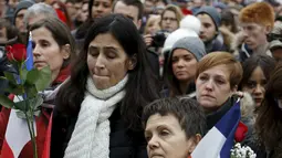 Sejumlah warga berdoa sambil membawa bendera Perancis di balai kota Toronto, Sabtu  (14/11/2015). Mereka berdoa untuk para korban yang tewas dalam peristiwa serangan di Paris. (REUTERS/Chris Helgren)