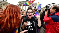 Seorang wanita merayakan keputusan legalisasi undang-undang pernikahan sesama jenis di depan Gerbang Brandenburg di Berlin (30/6). Dengan keputusan itu, maka UU pernikahan sejenis ini akan berlaku pada akhir tahun ini. (AFP Photo/Tobias Schwarz)