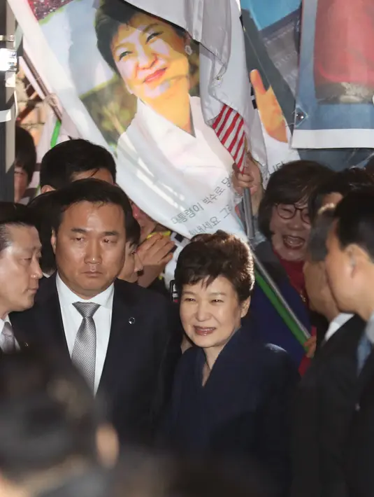Mantan Presiden Korea Selatan Park Geun-hye  tersenyum kepada pendukung yang menunggu di rumah pribadinya di Seoul, Minggu (12/3). Geun-hye meninggalkan Blue House setelah resmi dimakzulkan Mahkamah Konstitusi (MK) Korsel. (See Myung-gon/Yonhap via AP)