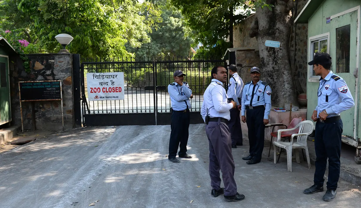 Penjaga keamanan berdiri di dekat gerbang utama Kebun Binatang Delhi di New Delhi, India, Rabu (19/10). Kebun binatang ditutup karena wabah flu burung yang menyerang hewan di kebun binatang tersebut. (AFP PHOTO / Sajjad Hussain)