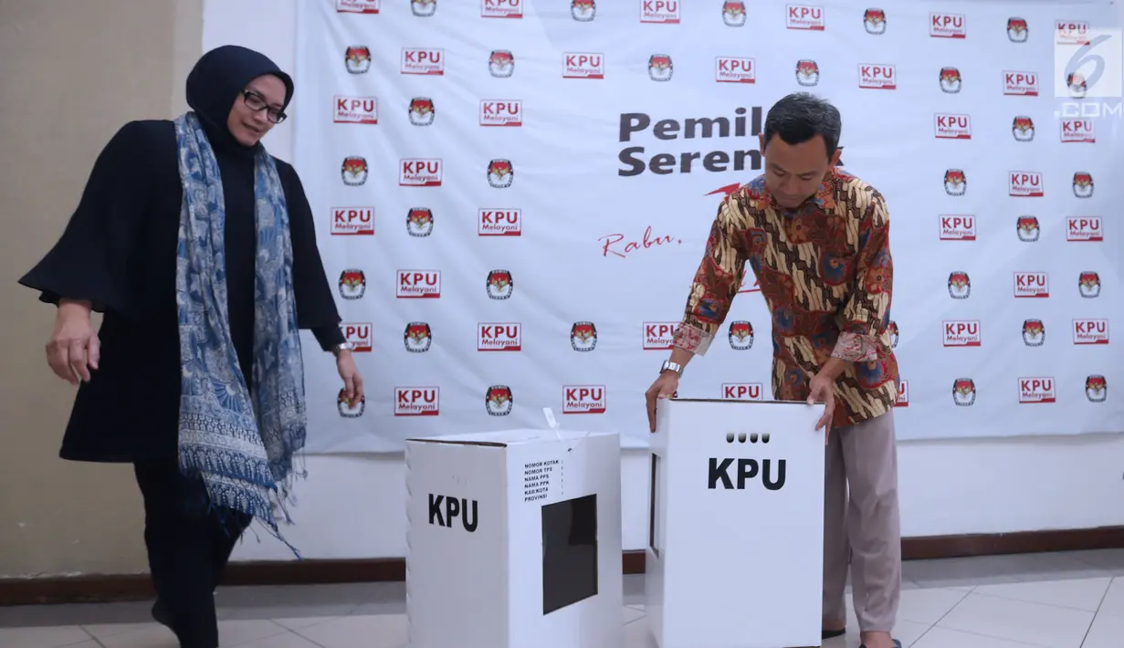 Komisioner KPU RI, Evi Novida GM (kiri) dan Pramono UT menunjukan kotak suara bermaterial karton kedap air dan transparan di Kantor KPU, Jakarta, Jumat (14/12). Kotak suara nantinya digunakan pada Pemilu Serentak 2019. (Liputan6.com/Helmi Fithriansyah)