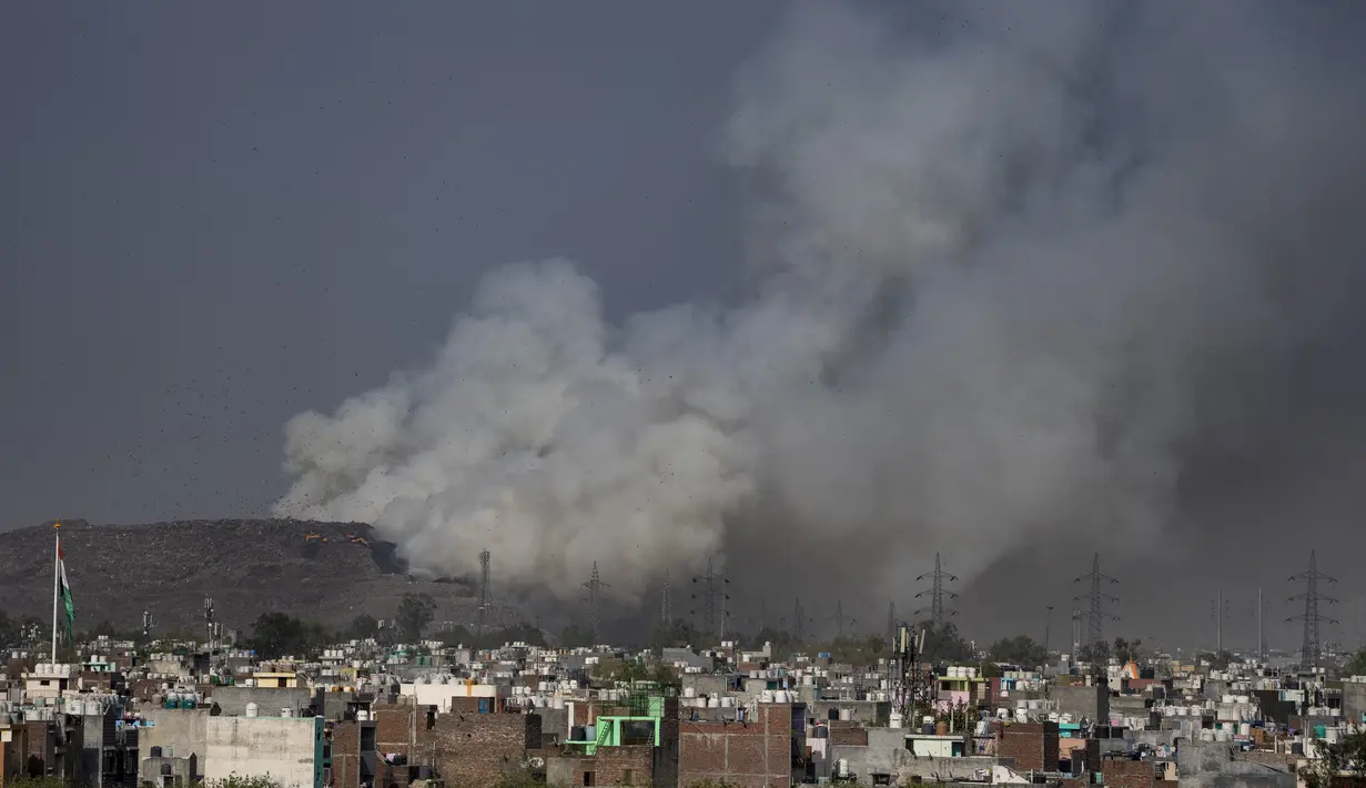 Asap mengepul dari TPA Ghazipur yang sebagian terbakar di pinggiran New Delhi, India (28/3/2022). Kebakaran besar terjadi di tempat pembuangan sampah di daerah Ghazipur Delhi timur yang menyebabkan kepulan asap besar menyelimuti wilayah tersebut dan daerah tetangga. (AP Photo/Altaf Qadri)