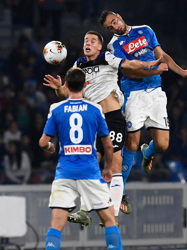 Pemain Atalanta Mario Pasalic melompat saat berebut bola dengan bek Napoli Nikola Maksimovic dalam laga pekan kesepuluh Liga Italia di Stadion San Paolo, Naples, Rabu (30/10/2019). Napoli dipaksa bermain imbang 2-2 oleh Atalanta. (Ciro Fusco/ANSA via AP)