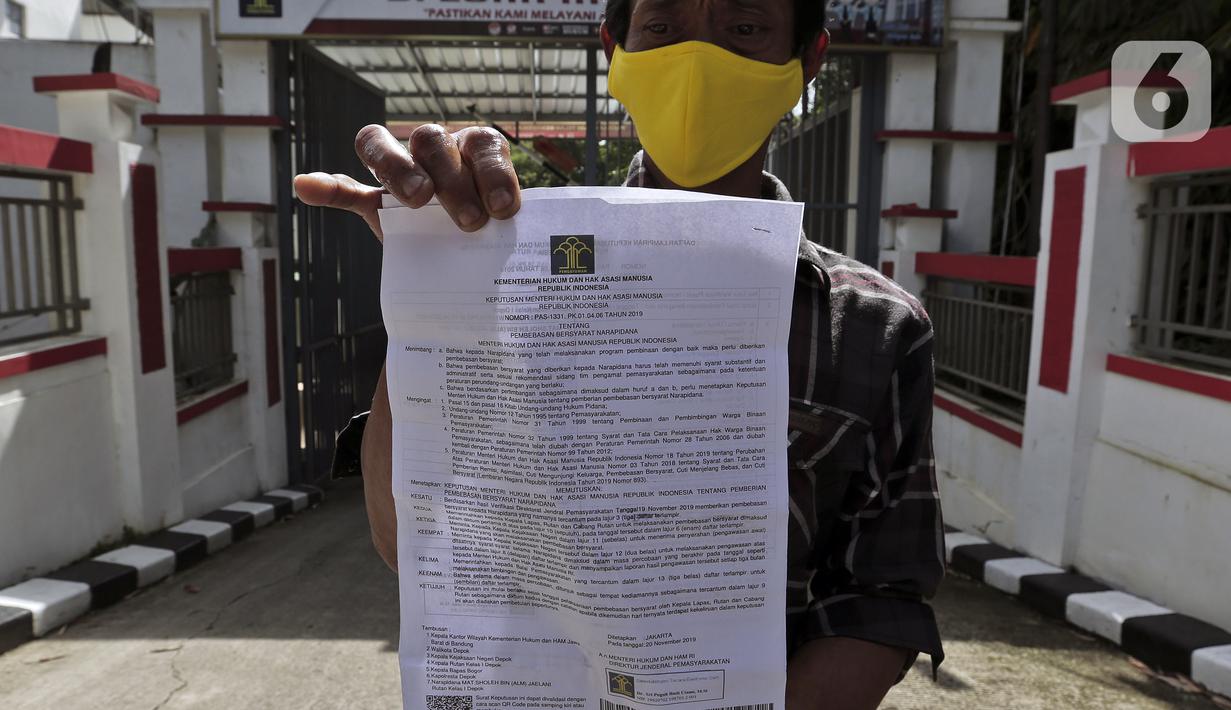 Narapidana menunjukan surat  usai mendapat pembebasan bersyarat melalui program asimilasi dan integrasi terkait pandemi virus corona COVID-19 di Rutan Kelas I Depok, Jawa Barat, Selasa (7/4/2020). Sekitar 290 narapidana mendapatkan pembebasan bersyarat. (Liputan6.com/Johan Tallo)