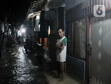 Warga berada di depan rumah saat banjir di kawasan Cipinang, Jakarta Timur, Minggu (23/2/2020) dini hari. Hujan deras yang mengguyur Jakarta dan sekitarnya sejak Sabtu malam ditambah buruknya drainase menyebabkan ratusan rumah di Cipinang terendam banjir. (merdeka.com/Iqbal S. Nugroho)