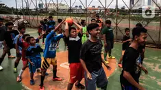 Anak-anak berlatih sepak bola di lapangan samping Banjir Kanal Barat (BKB), Jakarta, Kamis (7/1/2020). Revitalisasi jalur hijau di sepanjang aliran BKB menyulap kawasan kumuh menjadi tempat interaktif warga sekitar yang dilengkapi fasilitas bermain, seperti lapangan futsal. (Liputan6.com/Johan Tallo