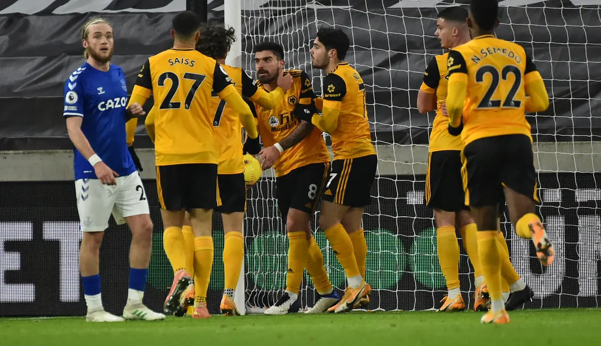 Gelandang Wolverhampton Wanderers, Ruben Neves (tengah) bersama rekan setim merayakan gol penyeimbang 1-1 ke gawang Everton dalam laga lanjutan Liga Inggris 2020/21 di Molineux Stadium, Selasa (12/1/2021). Wolverhampton Wanderers kalah 1-2 dari Everton. (AFP/Rui Vieira/Pool)