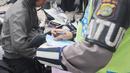 Anggota Satlantas Polres Tangerang Selatan memeriksa kelengkapan surat saat razia pajak kendaraan di Jalan BSD, Tangerang Selatan, Kamis (24/1). Razia ini untuk mendisiplinkan pengendara terhadap pembayaran pajak kendaran. (Merdeka.com/Arie Basuki)
