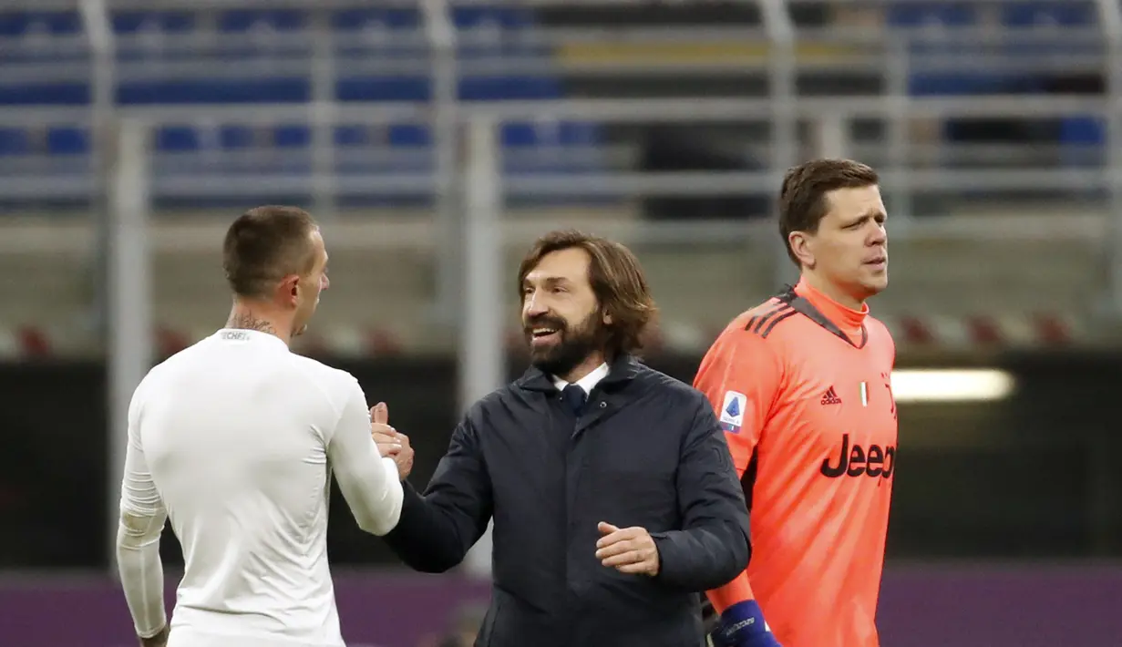 Pelatih Juventus, Andrea Pirlo (tengah) tersenyum dengan Federico Bernardeschi usai pertandingan lanjutan Liga Serie A Italia melawan AC Milan di stadion San Siro, Rabu (7/1/2021). Rekor tak terkalahkan AC Milan patah. Rossoneri takluk 1-3 dari Juventus. (AP Photo/Antonio Calanni)