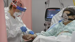 Seorang wanita mendapat suntikan di ruang gawat darurat yang berubah menjadi unit COVID-19 di rumah sakit Bagdasar-Arseni, Bucharest, Selasa (12/10/2021). Rumania pada Selasa mencatatkan jumlah tertinggi infeksi corona dan kematian dalam sehari sejak pandemi dimulai (AP Photo/Andreea Alexandru)