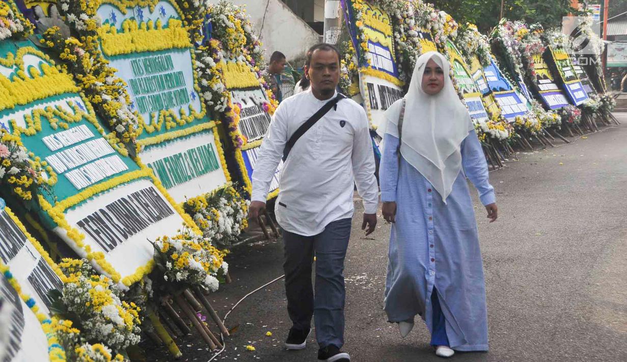 Warga berjalan di sekitar tempat persemayaman Ani Yudhoyono di Puri Cikeas, Bogor, Jawa Barat, Minggu (2/6/2019). Ani Yudhoyono akan dimakamkan di TMP Kalibata pada pukul 15.00 WIB.(Liputan6.com/Immanuel Antonius)