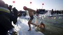 Para peserta keluar dari kolam renang yang terbuat dari sungai Songhua yang membeku pada Kompetisi Renang Es Harbin di Provinsi Heilongjiang, Senin (5/1/2016). (REUTERS/Aly Song)