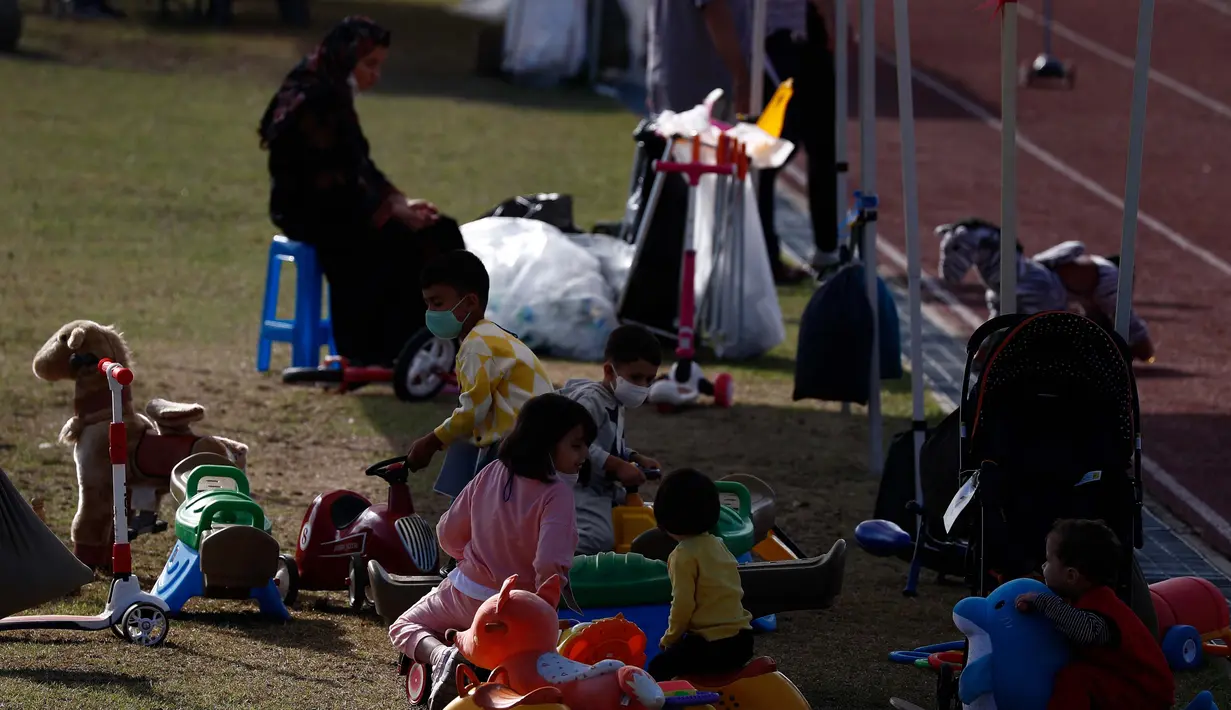 Anggota keluarga berada di taman bermain Institut Pengembangan Sumber Daya Manusia Nasional di Jincheon, Korea Selatan (13/10/2021). Para pengungsi muncul di hadapan publik pada hari Rabu, untuk pertama kalinya sejak mereka tiba pada akhir Agustus. (AFP/Pool/Jeon Heon-kyun)