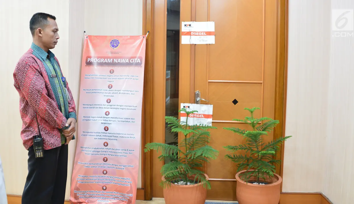 Petugas berjaga di pintu ruangan Dirjen Perhubungan Laut Kementerian Perhubungan Antonius Tonny Budiono di Gedung Karsa Kemenhub, Jakarta, Kamis (24/8). Penyegelan terkait Operasi Tangkap Tangan (OTT) terhadap pejabat di Kemenhub. (Liputan6.com/Pool)