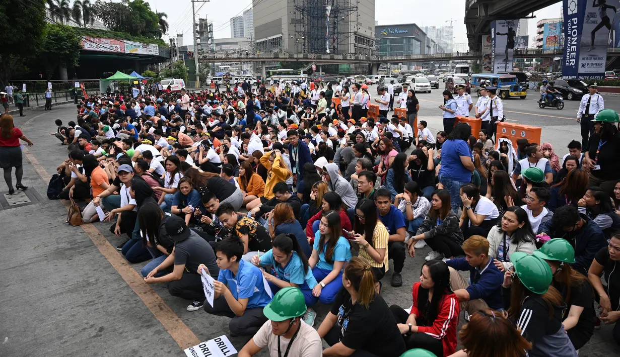 Karyawan pusat perbelanjaan berpartisipasi dalam latihan gempa di Manila (14/11/2019). Latihan ini sebagai bagian dari kesiapsiagaan nasional menyusul berbagai gempa yang melanda pulau Mindanao bulan lalu. (AFP Photo/Ted Aljibe)