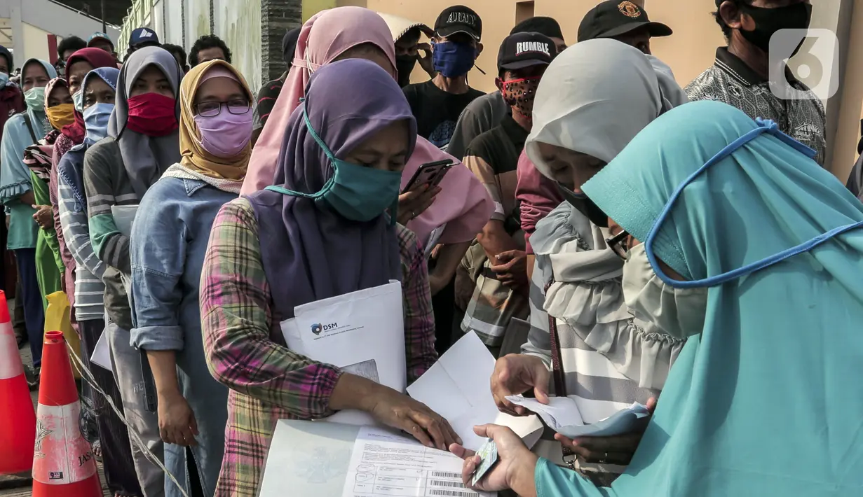 Warga antre untuk menerima Bantuan Sosial Tunai (BST) di Desa Cikande, Kecamatan Jayanti, Kabupaten Tangerang, Banten, Selasa (23/6/2020). Bantuan sebesar Rp 600 ribu per keluarga tersebut diharapkan bisa dimanfaatkan untuk membeli kebutuhan mendesak. (Liputan6.com/Johan Tallo)