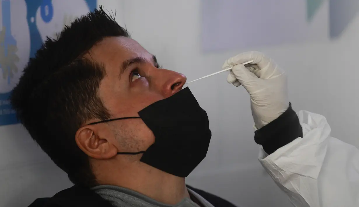 Petugas kesehatan mengambil sampel lendir hidung saa tes COVID-19 seorang penumpang, di bandara internasional Benito Juarez, Mexico City, Jumat (8/1/2022). Meksiko secara resmi mencatat 300.101 kematian sejak Maret 2020, termasuk 168 dalam 24 jam terakhir. (PEDRO PARDO/AFP)