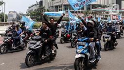 Buruh mengibarkan bendera saat melakukan konvoi menggunakan sepeda motor di Bundaran Hotel Indonesia untuk mengikuti unjuk rasa di depan Gedung DPR, Jakarta, Rabu (10/8/2022). Dalam aksi tersebut mereka menuntut agar pemerintah menghapus Omnibus Law. (Liputan6.com/Johan Tallo)