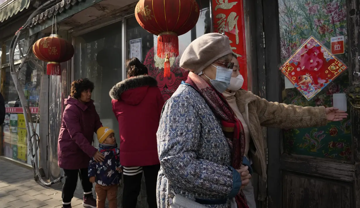 Warga berbaris untuk makan pangsit seperti yang biasa dilakukan selama hari titik balik matahari musim dingin di Beijing, China, Selasa (21/12/2021). Pangsit adalah makanan festival selama hari titik balik matahari musim dingin. (AP Photo/Ng Han Guan)
