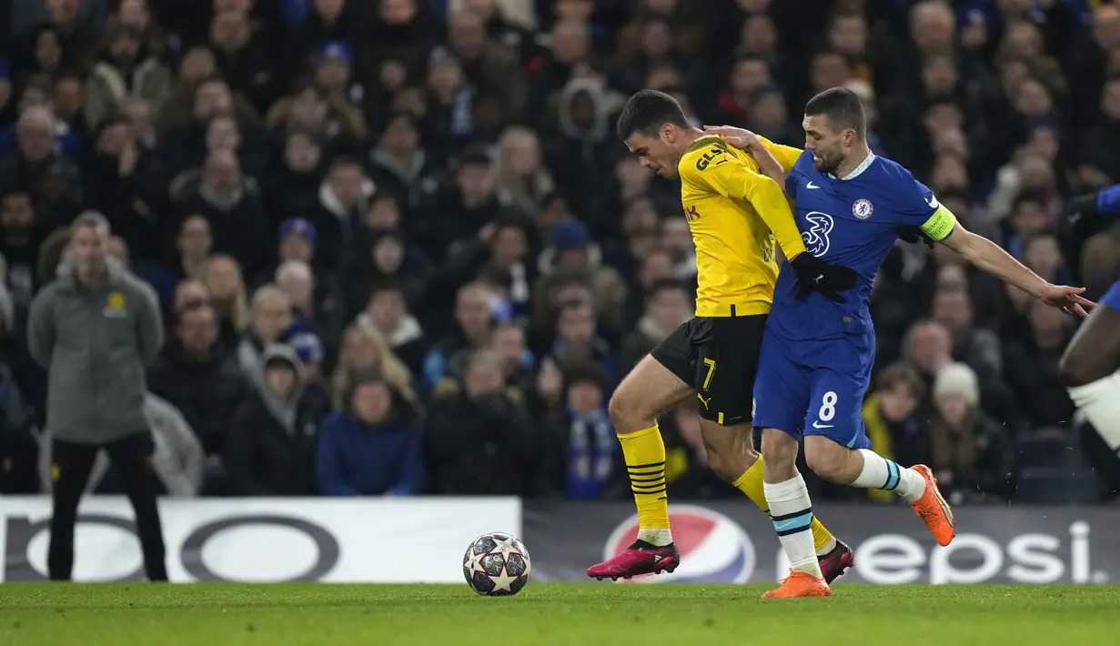 Gelandang Chelsea, Mateo Kovacic berusaha merebut bola dari pemain Borussia Dortmund, Giovanni Reyna selama pertandingan babak 16 besar Liga Champions di Stamford Bridge, London, Rabu (8/3/2023).Chelsea menang atas Dortmund dengan skor 2-0 dan melaju ke perempatfinal dengan agregat 2-1. (AP Photo/Alastair Grant)