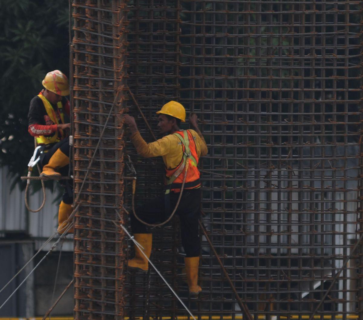 Pekerja menyelesaikan pemasangan rangkaian kawat baja di salah satu proyek pembangunan gedung di Jakarta, Kamis (25/4/2024). Kenaikan realisasi anggaran infrastruktur dalam Anggaran Pendapatan dan Belanja Negara (APBN) 2023 tak sebanding dengan serapan te