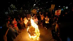 Pengunjuk rasa membakar boneka Donald Trump di pusat kota Los Angeles, California, Rabu (9/11). Sebagian warga AS turun ke jalan-jalan di seluruh wilayah Amerika Serikat tak terima dengan kemenangan Donald Trump dalam Pilpres AS. (REUTERS/Mario Anzuoni)