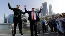 Kim Jong-un KW bernama Howard X dan Donald Trump KW, Dennis Alan berpose sambil melompat bersama di Merlion Park, Singapura (8/6). Dua orang yang mirip pemimpin negara Korut dan AS ini menghebohkan warga dan pengunjung. (AP/Wong Maye-E)