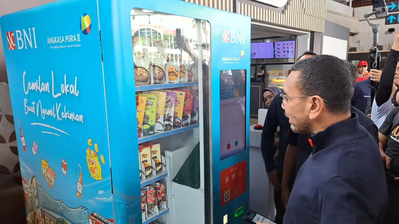 Staf Khusus III Menteri BUMN Arya Sinulingga tengah mencoba bertransaksi di vending machine produk UMKM, di Terminal 1A, Bandara Internasional Soekarno Hatta, Selasa (30/1/2024).