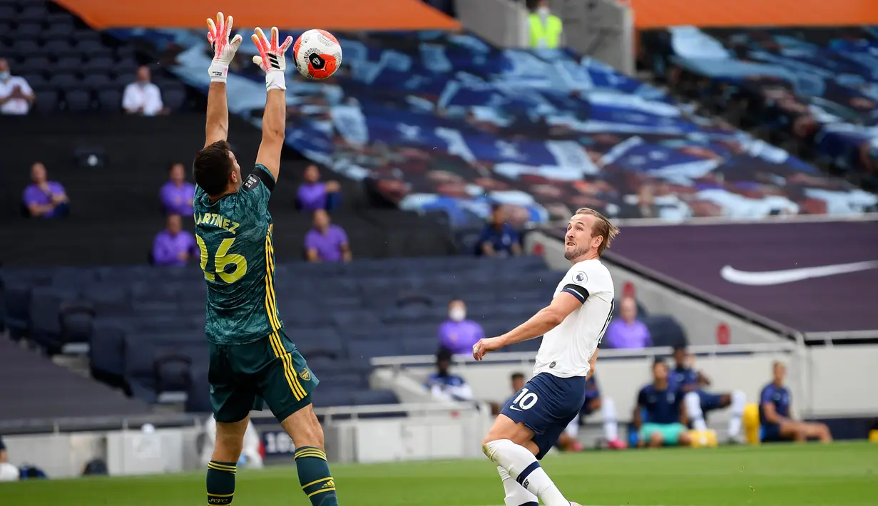 Kiper Arsenal Emiliano Martinez berusaha menangkap bola tembakan striker Tottenham Hotspur, Harry Kane pada pertandingan lanjutan Liga Inggris di Stadion Tottenham Hotspur di London, Inggris, Minggu (12/7/2020). Tottenham menang tipis atas Arsenal 2-1. (Michael Regan/Pool via AP)