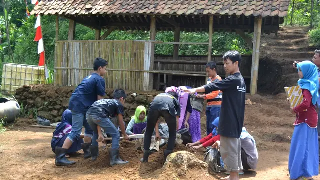 Isrodin mendampingi siswa MTs Pakis berpraktik mendeder benih pakis hutan. Pakis hutan itu akan dijual sebagai penambah biaya operasional sekolah. (Foto: Liputan6.com/Muhamad Ridlo)