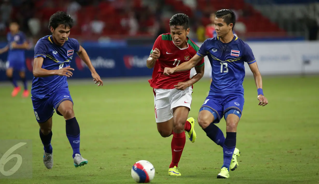 Penyerang timnas Indonesia U-23, Yandi Sofyan M (tengah) mencoba melewati Narubadin Weerawatnodom (Thailand) di semifinal sepak bola SEA Games ke-28 di National Stadium Singapore, Sabtu (13/6/2015). Indonesia kalah 0-5. (Liputan6.com/Helmi Fithriansyah)