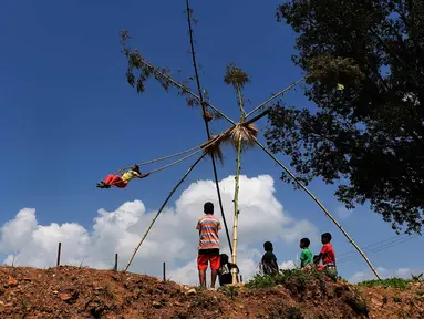 Anak-anak bermain di ayunan khas negara Nepal di Lalitpur pinggiran kota Kathmandu, Nepal (26/9). Ayunan yang dikenal dengan sebutan 'Dashain Ping' ini bisa dimainkan orang-orang dari segala usia. (AFP Photo/Prakash Mathema)