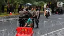 Polisi foto bersama saat menjaga akses jalan menuju Istana Negara, Jakarta, Senin (14/10/2019). Hingga sore hari, polisi masih menutup jalan dikarenakan isu adanya demo mahasiswa yang akan berlangsung hari ini. (Liputan6.com/JohanTallo)