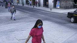 Warga berjalan menggunakan masker  melindungi diri dari abu vulkanik usai letusan gunung berapi Popocatepetl di Puebla, Meksiko, (18/4). Pemerintah Meksiko mengatakan gunung Popocatepetl menyemburkan abu vulkanis setinggi 3 km. (REUTERS/Imelda Medina)