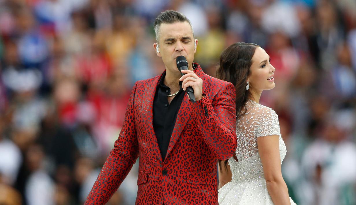 Penyanyi asal Inggris, Robbie Williams, berduet dengan penyanyi soprano Rusia Aida Garifullina pada upacara pembukaan Piala Dunia 2018 di Stadion Luzhniki, Moskow, Kamis (14/6). Keduanya berkolaborasi di lagu Angel milik Williams. (AP/Pavel Golovkin)