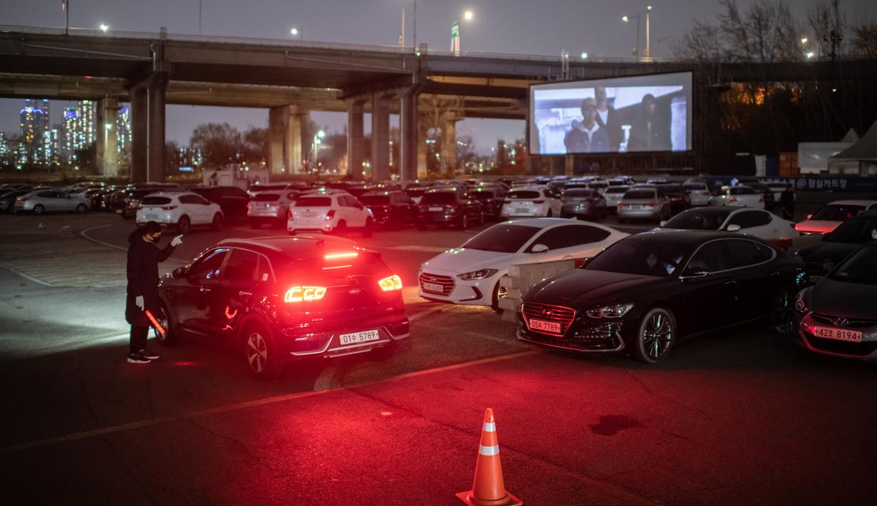 Sebuah layar terbuka menunjukkan film yang sedang diputar di sebuah bioskop kendara atau drive-in cinema di Seoul, Korea Selatan, 21 Maret 2020. Jenis bioskop ini menjadi pilihan yang lebih bagi warga Seoul untuk menikmati film di tengah pandemi virus corona Covid-19. (Ed JONES/AFP)