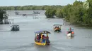Perahu wisata melintasi kawasan hutan mangrove di Wisata Mangrove, Tarumajaya, Bekasi, Minggu (30/12). Wisata yang berbatasan dengan kawasan Marunda Jakarta Utara awalnya merupakan Pusat Restorasi dan Pembelajaran Mangrove. (merdeka.com/Arie Basuki)