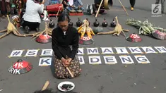 Salah satu petani Kendeng terduduk saat aksi di depan Istana Negara, Jakarta, Kamis (2/8). Dalam aksinya, petani Kendeng melakukan tradisi Brokohan atau makan bersama nasi aneka urap yang sebelumnya didoakan. (Liputan6.com/Helmi Fithriansyah)