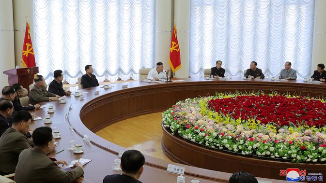 Pemimpin Korea Utara, Kim Jong-un (tengah) menghadiri pertemuan politbiro ke-13 dari Partai Buruh di lokasi yang dirahasiakan dalam gambar yang diambil Minggu (7/6/2020). Dalam pertemuan itu, Kim Jong-un juga membahas proyek-proyek ekonomi termasuk industri kimia. (Photo by STR / KCNA VIA KNS / AFP)
