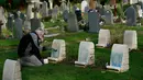 Petugas membersihkan batu nisan kuburan Harefield di Hillingdon, Inggris, Rabu (23/11). Kuburan prajurit Australia & New Zealand yang tewas pada Perang Dunia I dicoret dengan graffiti kedua kalinya dalam 7 bulan terakhir di London (REUTERS/Stefan Wermuth)