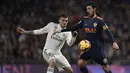 Gelandang Real Madrid, Daniel Ceballos, berebut bola dengan gelandang Valencia, Daniel Parejo, pada laga La Liga di Stadion Santiago Bernabeu, Madrid, Sabtu (1/12). Madrid menang 2-0 atas Valencia. (AFP/Oscar Del Pozo)