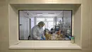 Pekerja medis berada di sebelah deretan jasad dalam kantong plastik hitam di ruang pemakaman rumah sakit yang merawat pasien COVID-19 di Kiev pada 2 November 2021. Salah satu negara termiskin di Eropa, Ukraina, telah dilanda lonjakan infeksi virus corona varian Delta. (Sergei SUPINSKY/AFP)