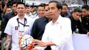 Presiden Joko Widodo bersiap melempar bola saat pembukaan turnamen Piala Presiden 2017 di Stadion Maguwoharjo, Sleman, Sabtu (4/2). Sekitar 31.000 penonton menyaksikan laga pembuka turnamen Piala Presiden 2017. (Liputan6.com/Helmi Fithriansyah)